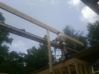 Carpenter setting a ridge beam over a new addition frame — Ice Dam Removal by Roofing Brothers in East Moline
