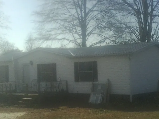 New metal roof on a white painted brick home on a foggy morning in East Moline