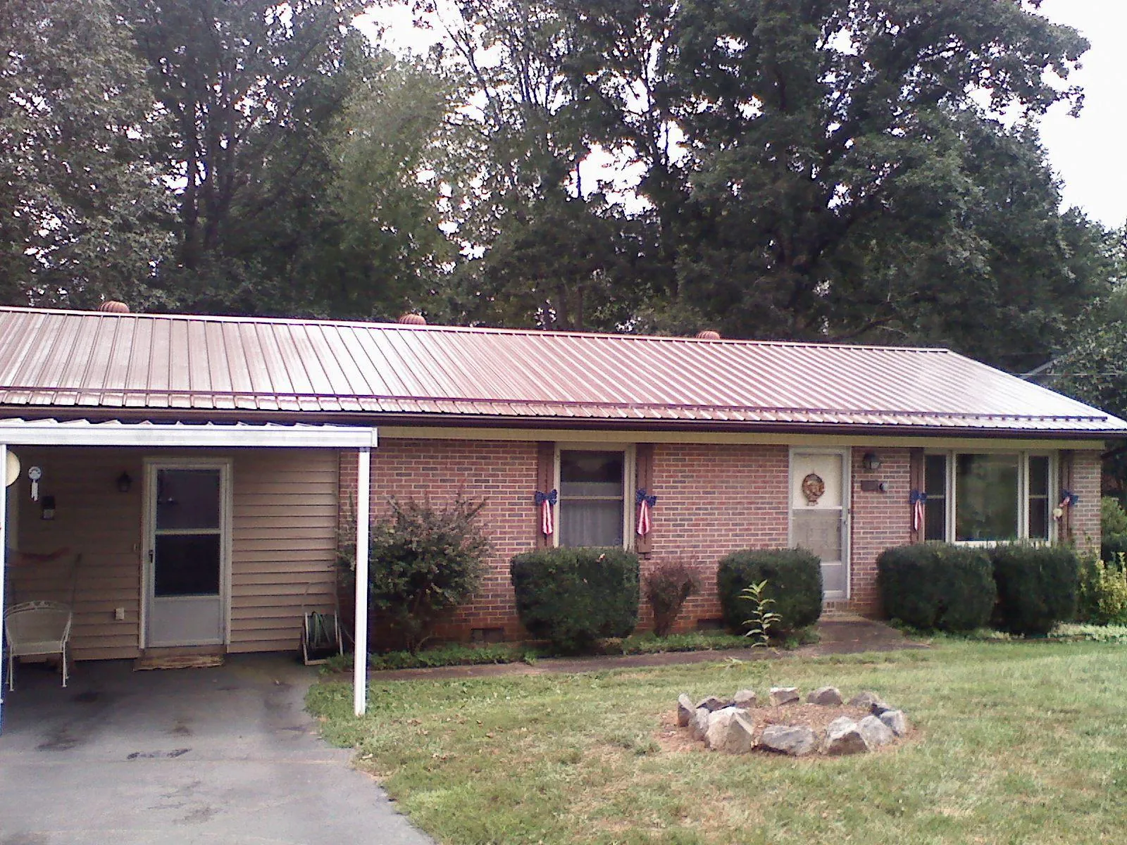 Bronze metal roof and carport on a brick ranch home — Roof Repair work by our crew in East Moline